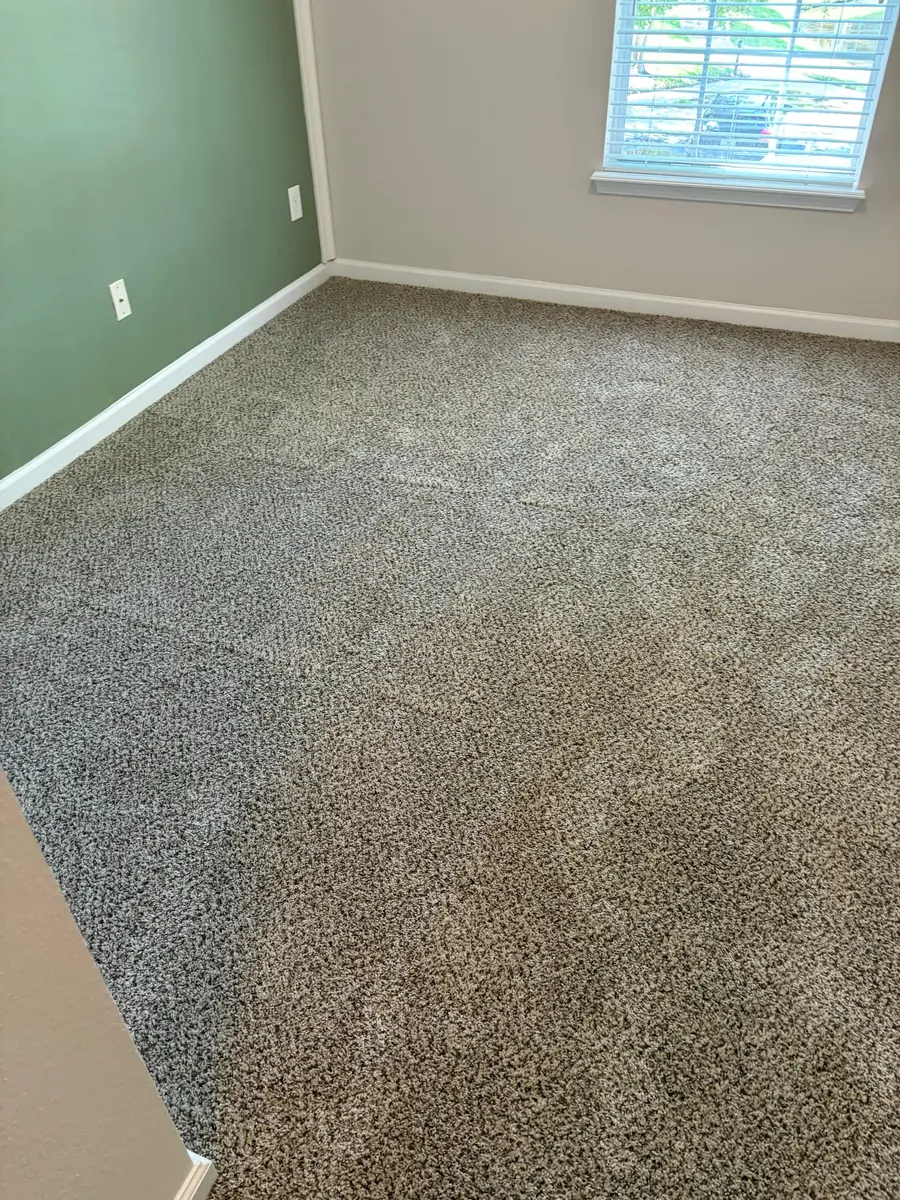 Finished wall-to-wall carpet in a bedroom with a window