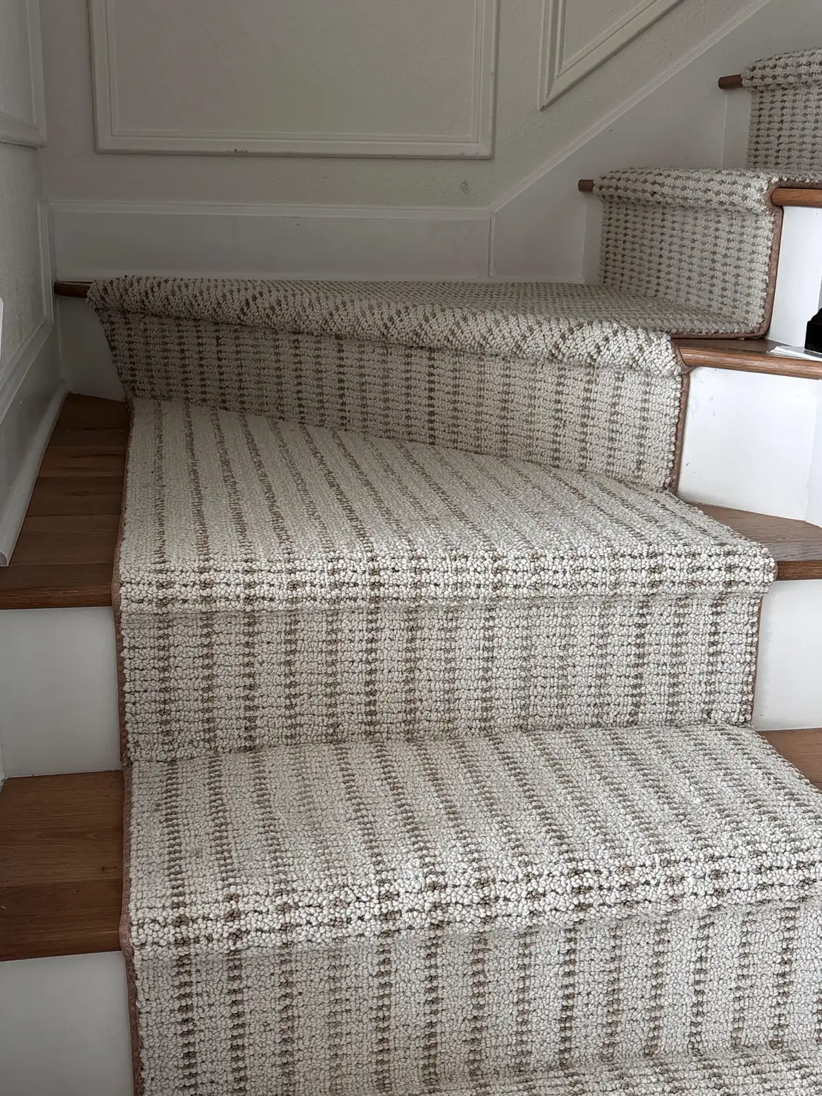 Custom bound carpet runner fitted over stained wood stair treads