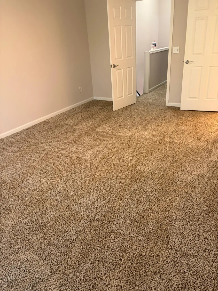 Newly installed beige carpet in an empty room with open doors