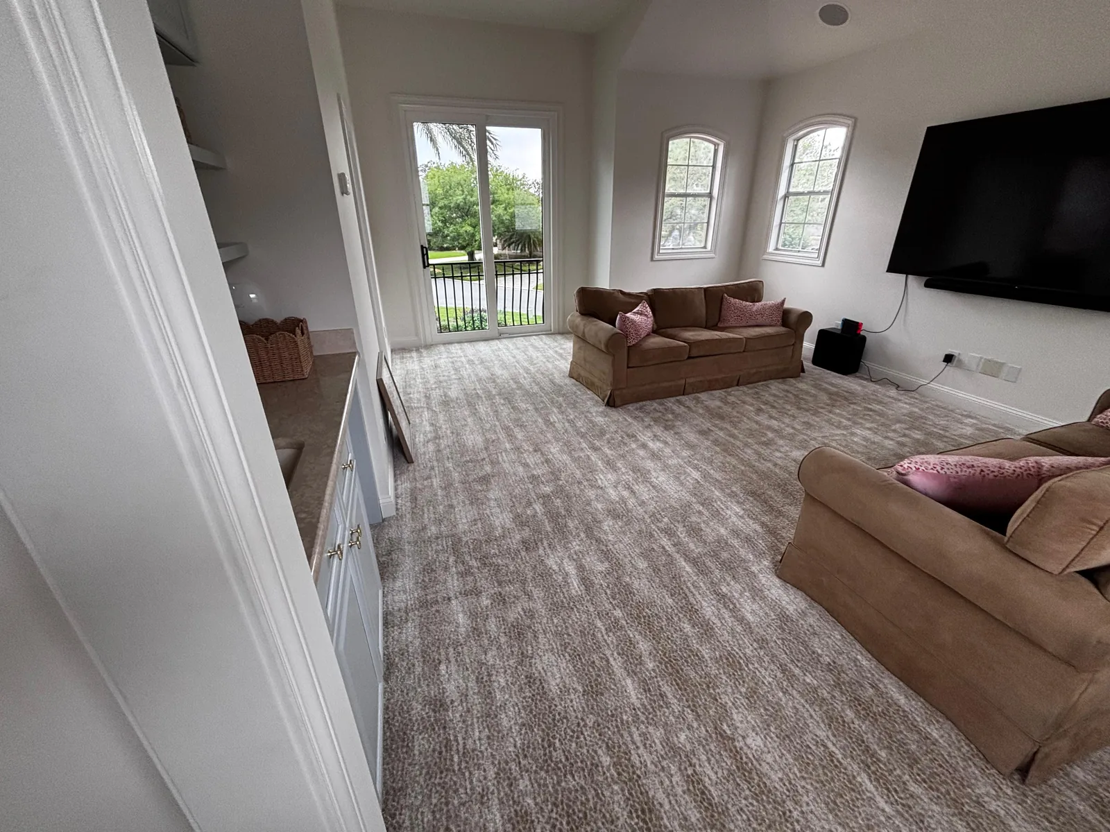 Wall-to-wall carpet in a furnished living room with tall windows