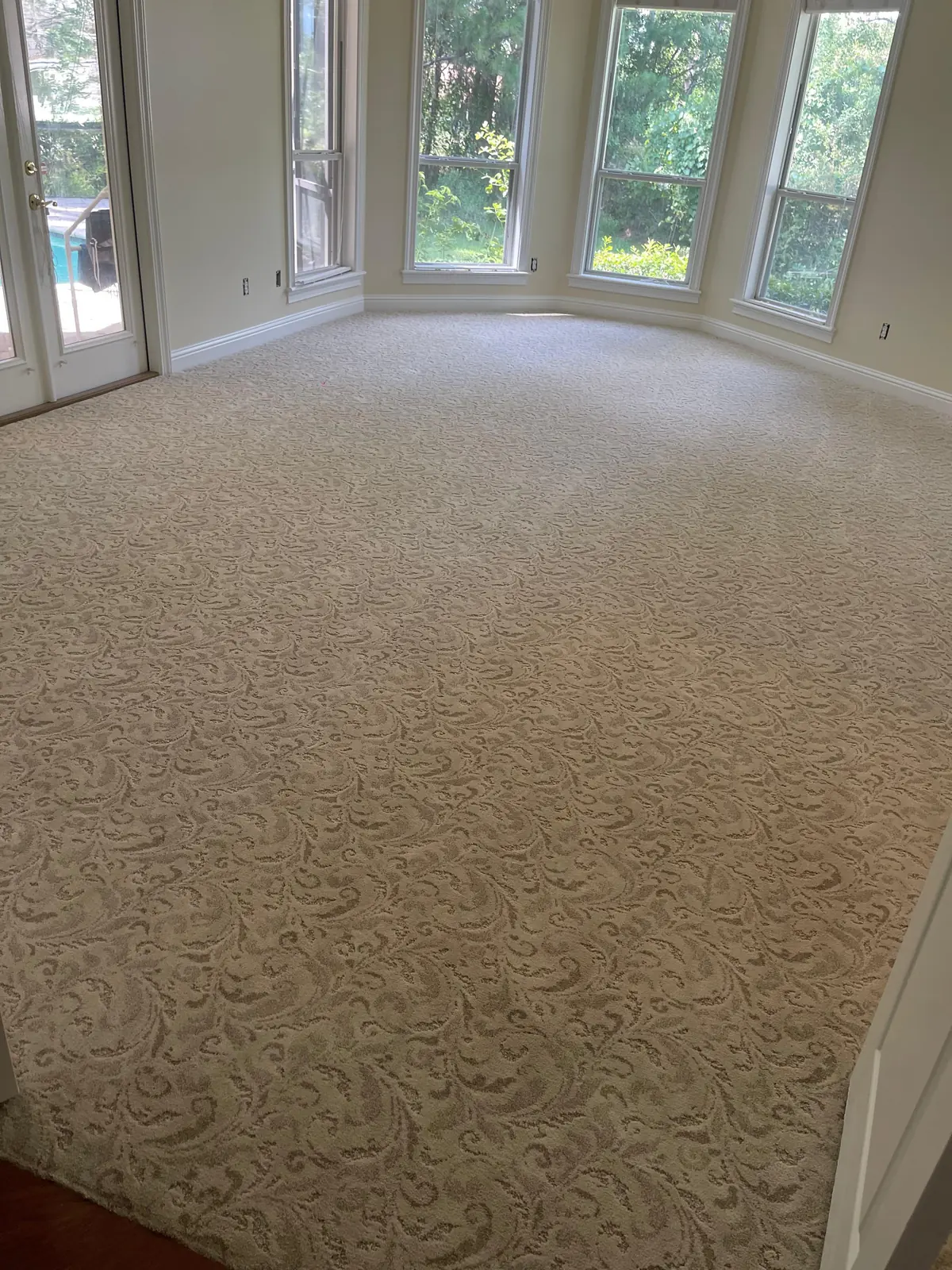 Cream patterned carpet in a room with a bay window