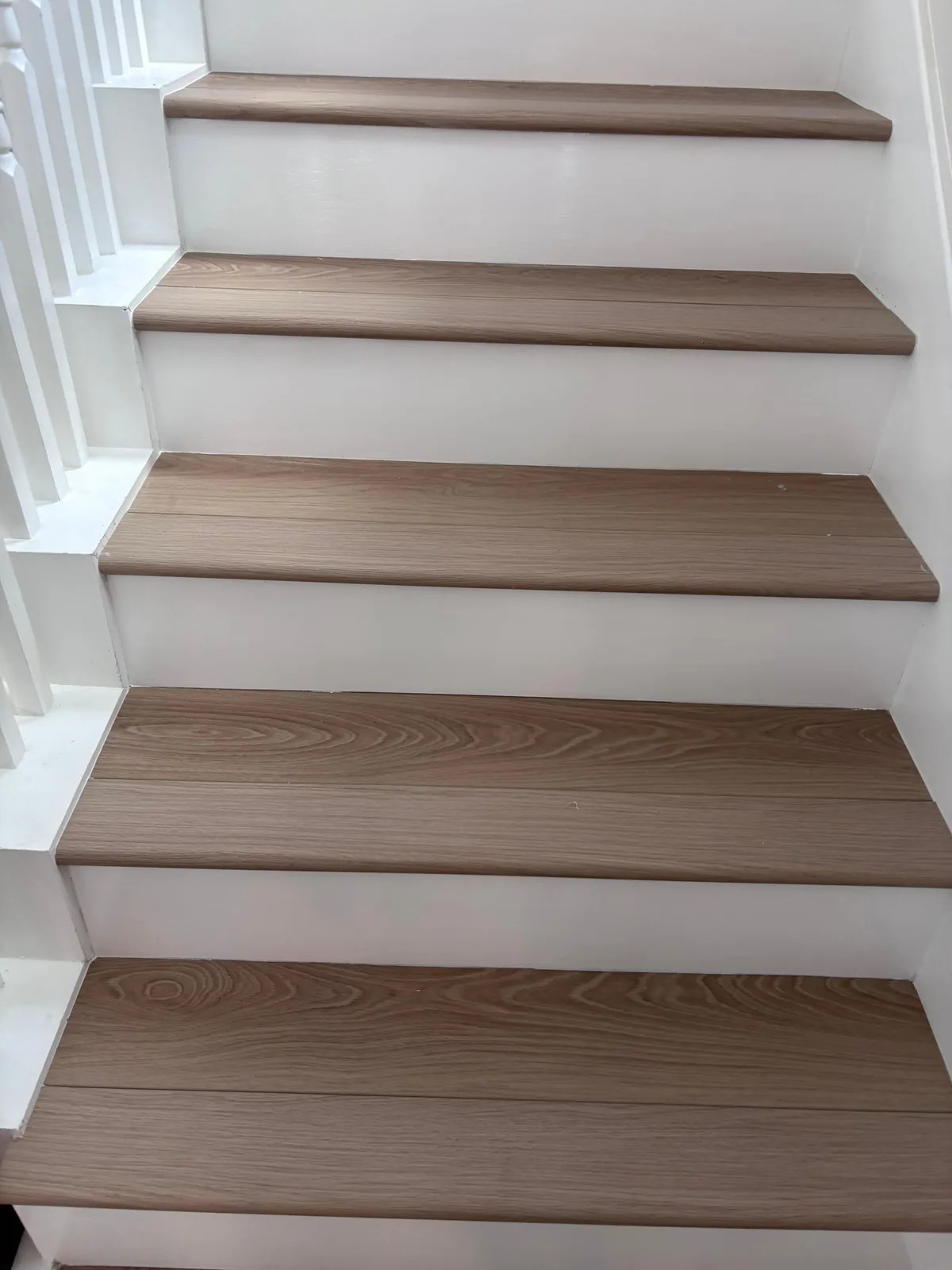 Close view of finished hardwood stair treads and white risers