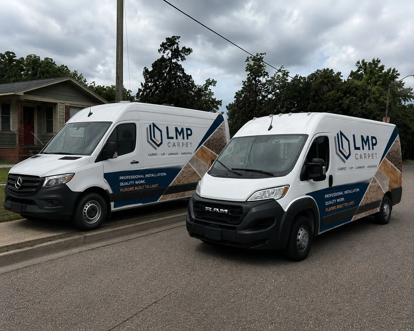 Two LMP Carpet branded work vans parked on a residential street
