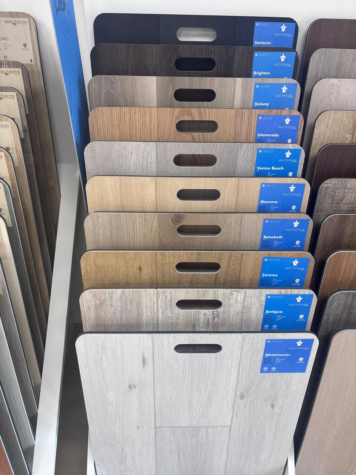 Rack of luxury vinyl plank samples in a range of wood tones