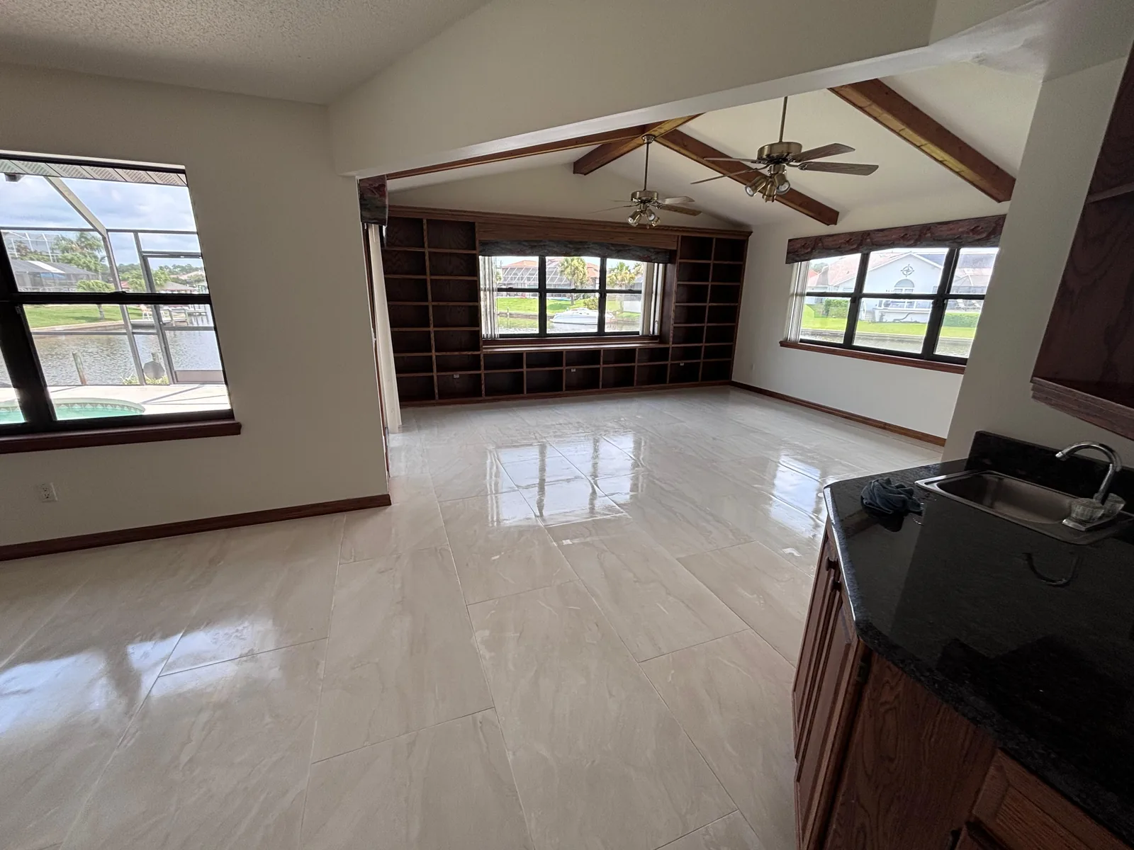 Porcelain tile floor in a great room with exposed ceiling beams