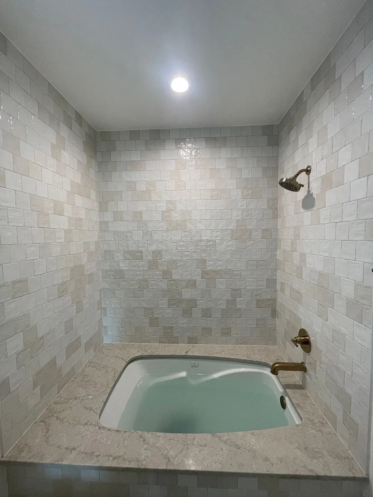 Finished tile tub surround with a stone deck